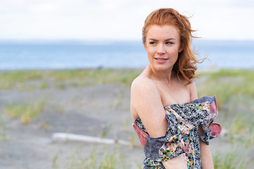 Fototapeta na wymiar Beautiful woman with red hair at the beach