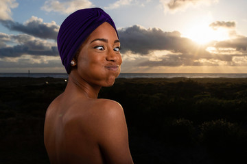 Portrait of beautiful African American woman at sunset wearing turban