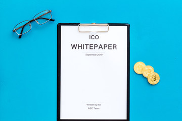 White paper ICO, coins, glasses on blue background top view