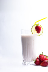 lime and ripe strawberries on a cocktail against white background