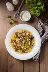 Soup of wild mushrooms (aspen, white, boletus) with vegetables, potatoes, pearl barley. Traditional Russian first course, delicious food for lunch, hot cozy dish