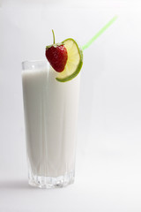 lime and ripe strawberries on a cocktail against white background