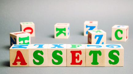 Wooden blocks with the word Assets and randomly scattered cubes. Resource owned by the business. Financial accounting. Money and finance. Cash equivalents, certificates of deposit