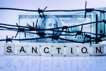 US Dollar money wrapped in barbed wire as symbol of economic warfare and sanctions