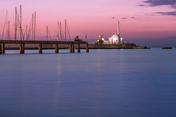 Fototapeta na wymiar Two lovers enjoying the sunset at the pier