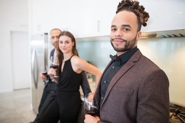 Group of friends together at cocktail party in home