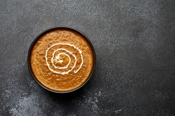 Dal Makhani at dark background. Dal Makhani - traditional indian cuisine puree dish with urad beans, red beans, butter, spices and cream. Copy space