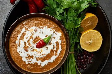 Dal Makhani at dark background. Dal Makhani - traditional indian cuisine puree dish with urad beans, red beans, butter, spices and cream.