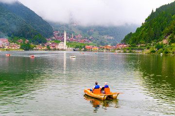 Panoramic view of Uzungol which is a tourist attraction in Trabzon, Turkey. The paddle boat on Uzungol. - obrazy, fototapety, plakaty