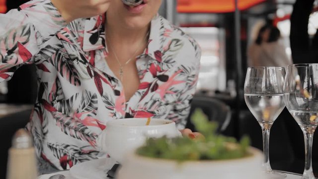 Unrecognized female tourist eats in a Paris restaurant. Close-up, Slow Motion.