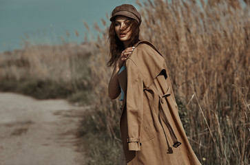 Beautiful Young Stylish Girl in Trench Coat Walking Autumn or Spring street. Autumn outdoor fashion.