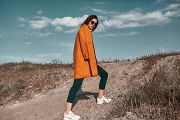 Autumn fashion. Beautiful attracrive young woman in bright autumn look. Orange trendy coat and...