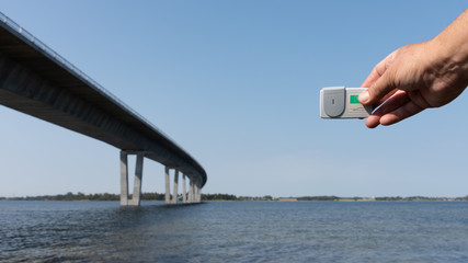 Holding a Brobizz decieve for payment over the Crown princess Mary Bridge in Frederikssund, Denmark