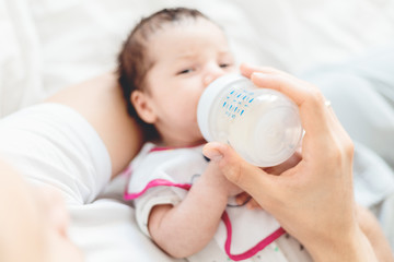 Obraz na płótnie Canvas Young white father feeding baby with bottle