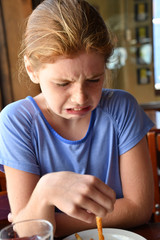 Girl looks disgusted trying new food