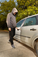 Addicted man in black hooded shirt stealing car