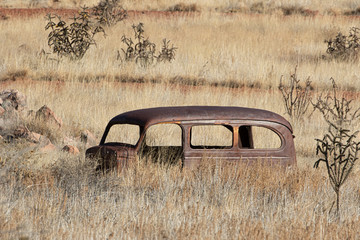 Old rusted car body in desert