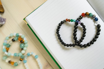 High angle view on crystal semiprecious stone beads bracelets gems natural stones for manifesting and healing energy handmade for good fortune on the table on notebook