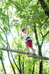 Naklejka na ściany i meble young boy, teenager, in a rope park, engage in extreme games, child development, boy hobbies