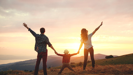 Fototapeta na wymiar Happy family: mother, father, child son a on sunset.