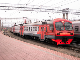 Obraz premium Przyjazd pociągu na stację kolejową w pochmurny dzień.