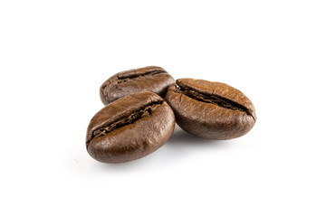 Three shiny fresh roasted coffee beans isolated on white background. Coffee background or texture concept.