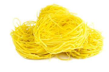 Raw yellow italian pasta pappardelle, fettuccine or tagliatelle close up. Homemade dry ribbon noodles, long rolled macaroni or uncooked spaghetti isolated