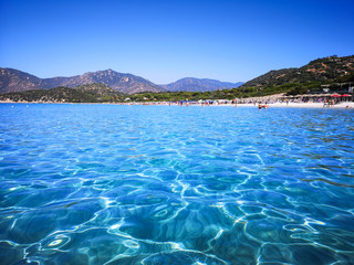 The blue clear water and white sand of a beach in Sardinia.