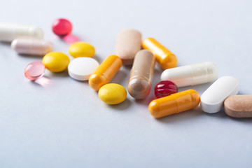 Vitamins and supplements on bright paper background. Concept for a healthy dietary supplementation. Close up. Copy space. 