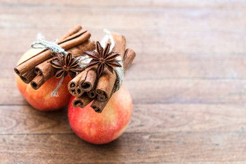 Red apple with cinnamon sticks spices decorated anise with star. Festive Merry Christmas composition. New year card. Holiday theme. Banner Background