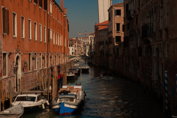 Venice canal with boats and vintage walls