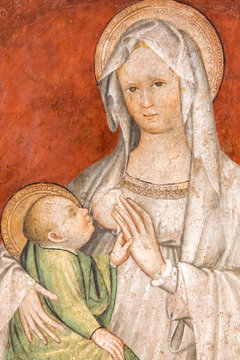 Religious medieval italian fresco showing Mary breast feeding baby Jesus