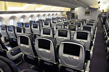 Fototapeta premium Commercial airplane seats with inflight entertainment displays/screens viewed from the rear
