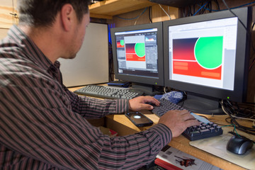 Man working on illustrations and photo editing with two black monitors