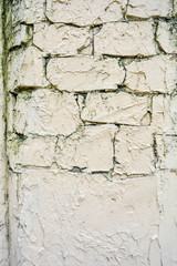 Texture of light yellow paint stucco on brick wall. Imitation of old castle wall