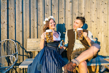 Junge Frau und mann mit Bierkrug und Brezel auf einem Holzhintergrund .Oktoberfest-Konzept 
