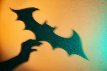 Hand holding a bat. Shadow reflection on the wall. Shadow theater. The Symbol Of Halloween. Bat...