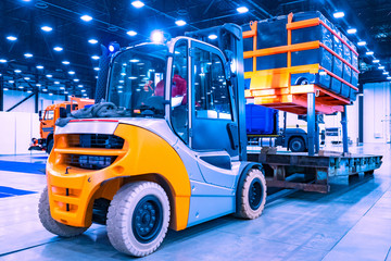 Hydraulic lift close-up. Heavy forklift moves the container. Warehouse loader for container transportation. Transportation of industrial equipment.
