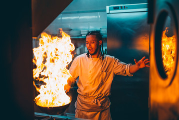 Chef cook with fire in pan, burning oil
