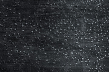 Water droplets on brushed metal. Stainless black steel textured background