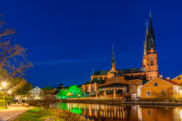 Sunset view of Uppsala cathedral reflecting on river Fyris in Sweden