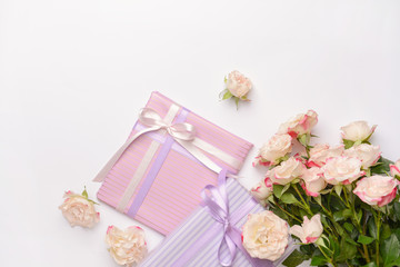 Gift boxes and beautiful flowers on light background