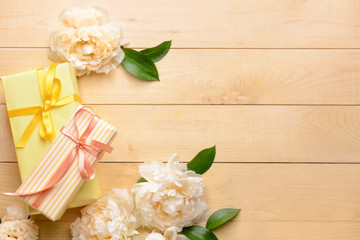 Gift boxes and beautiful flowers on wooden background