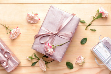 Gift boxes and beautiful flowers on wooden background