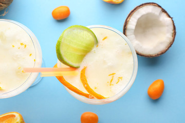 Glasses of tasty Pina Colada cocktail and fruits on color background