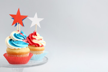 Tasty patriotic cupcakes on light background