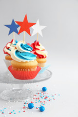 Tasty patriotic cupcakes on light background