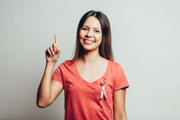 Healthcare and medicine concept - woman in t-shirt with pink breast cancer awareness ribbon