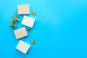 Soap bars with eucalyptus on color background