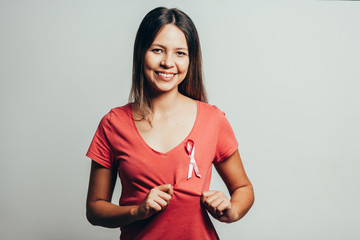 Healthcare and medicine concept - woman in t-shirt with pink breast cancer awareness ribbon
